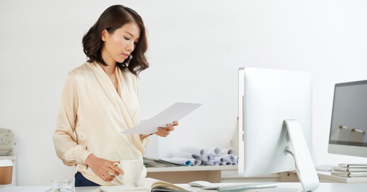 Business owner reviewing a compliance checklist to prepare for Singapore's NRIC authentication phase-out deadline